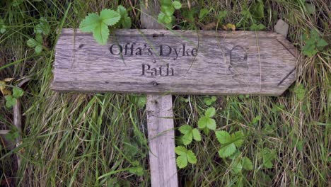 Still-shot-of-the-Offa's-Dyke-footpath-sign-post-laying-flat-on-the-grass