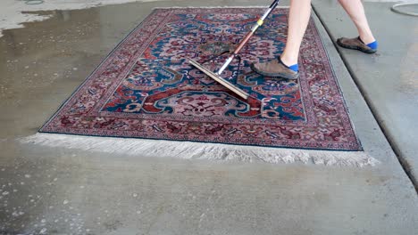 Using-a-squeegee-to-flush-water-off-a-newly-cleaned-oriental-carpet