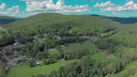 Long-drone-descent-into-a-valley-with-a-mountain-town-in-the-Catskill-Mountains-of-New-York-State