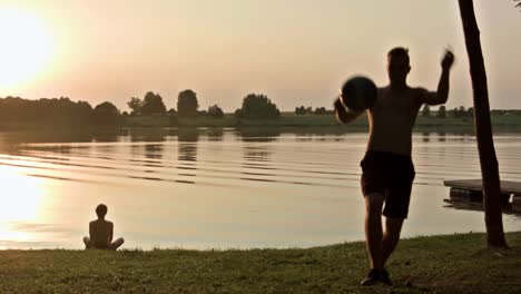 Man-juggling-soccer-ball-near-a-lake