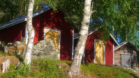 Traditional-Nordic-red-barns,-row-of-three-old-barns-in-Sweden-with-typical-colors