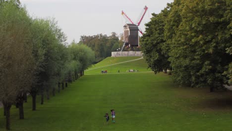 Two-siblings-playing-nearby-a-windmill-in-Bruges