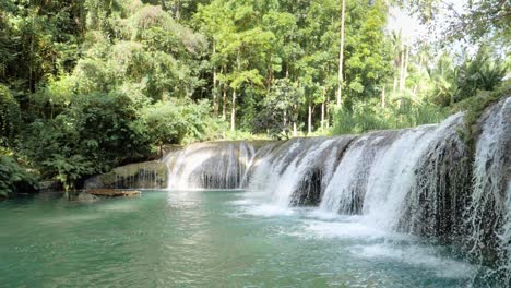 Stativaufnahme-Von-Wasser,-Das-Aus-Cambugahay-Fließt,-Fällt-In-Ein-Natürliches-Türkisfarbenes-Becken-Mit-Bambusfloß-Auf-Der-Insel-Siquijor,-Den-Philippinen,-In-Ultrazeitlupe