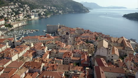 Imágenes-Aéreas-Del-Casco-Antiguo-De-Dubrovnik,-La-Cámara-Pasa-Sobre-La-Catedral-Y-El-Puerto-De-Dubrovnik-Mostrando-La-Costa-Distante