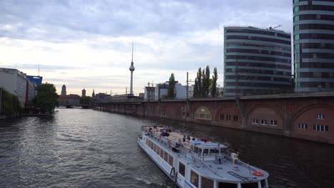 Touristic-Boat-Cruise-in-Berlin-on-river-Spree-at-sunset-with-tv-tower
