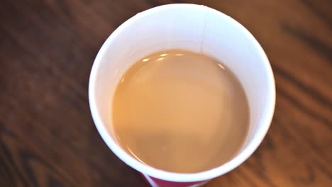 In-Einem-Café-Aufgenommener-Clip-Eines-Kaukasischen-Mannes,-Der-Aus-Einer-Kaffeetasse-Mit-Heißem-Kaffee-Oder-Tee-Trinkt-Und-Den-Deckel-Aufsetzt