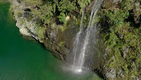 Wunderschöner-Wasserfall-Am-Wunderschönen,-Unberührten-Blauen,-Klaren-Pelorus-River,-Neuseeland-Mit-Felsen-Und-Einheimischem-üppigem-Wald-Im-Hintergrund---Luftdrohne