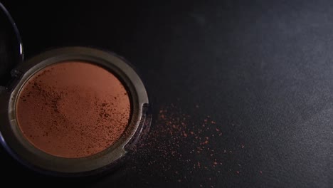 make-up-brushing-on-brown-face-make-up-powder-on-a-black-background