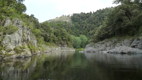 Beautiful-pristine-blue-clear-Pelorus-river,-New-Zealand-with-rocks-and-native-lush-forrest-in-background
