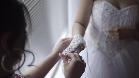 Helping-bride-with-her-dress-glove