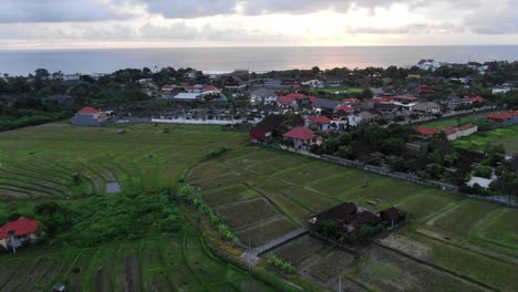Luftaufnahme-über-Bali-Reisfelder,-Die-Bei-Sonnenuntergang-In-Richtung-Meer-Fliegen