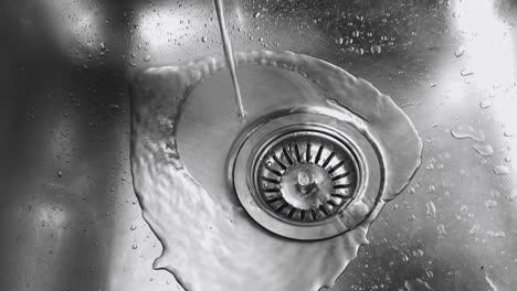 Close-up-view-from-above-of-water-pouring-into-a-stainless-steel-sink
