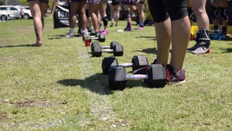 Shot-of-a-Line-of-Dumbbells-as-a-Group-of-Female-Athletes-Get-Ready-for-a-Crossfit-Competition