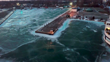 Ein-Pickup,-Der-Am-Ende-Eines-Docks-Steht-Und-Dessen-Scheinwerfer-Sich-Im-Winter-In-Kanada-Bei-Sonnenuntergang-Auf-Dem-Zugefrorenen-See-Spiegeln