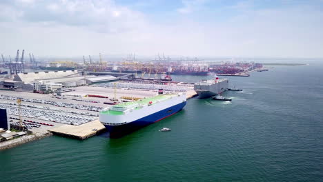 Aerial-view-of-logistics-concept-of-commercial-vehicles,-cars-and-pickup-trucks-waiting-to-be-load-on-to-a-roll-on-roll-off-car-carrier-ship