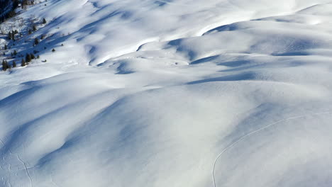 Vista-Aérea-Panorámica-Desde-Un-Campo-De-Nieve-Para-Revelar-El-Mont-Blanc-Y-Las-Montañas-Circundantes-Bajo-El-Sol,-En-Los-Alpes-Franceses-En-Invierno