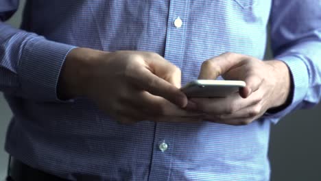 Man-using-smart-phone,-holding-and-typing-on-cell-phone-in-hands