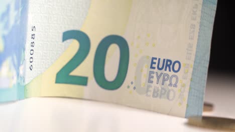 Close-up-of-20-euro-bill-and-coins,-movement-from-right-to-left