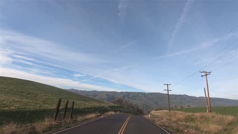 Conduciendo-Por-El-Campo-De-California-Con-Campos-Verdes-Y-Montañas-Al-Pie