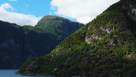Riesige-Geiranger-Fjordlandschaft,-Von-Einem-Kreuzfahrtschiff-Aus-Gesehen,-Große-Berge,-Die-In-4k-Aus-Dem-Blauen-Wasser-Ragen