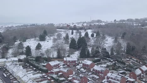 Forward-tracking-drone-shot-of-snowy-Exeter-over-a-wooded-area-CROP