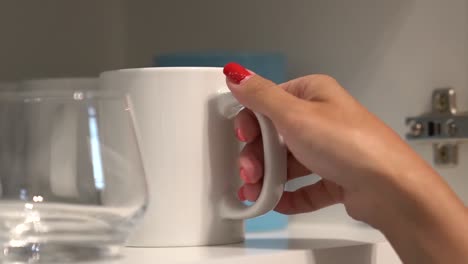 Woman-taking-out-a-white-cup-to-make-tea-or-coffee-in-the-morning
