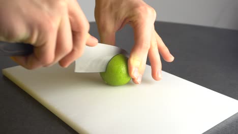 Eine-Limette-Mit-Einem-Küchenmesser-Spalten