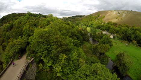 Aerial-view-of-cyclists-riding-over-the-Headstone-viaduct,-bridge-in-the-Derbyshire-Peak-District-National-Park,-Bakewell,-commonly-used-by-cyclists,-hikers,-popular-with-tourists-and-holiday-makers