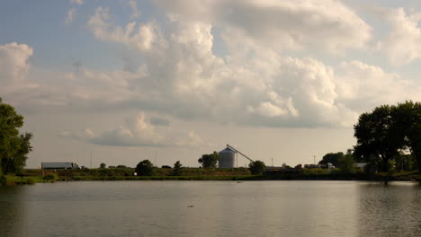 Time-lapsed-scene-of-grain-silo,-highway-and-pond-in-Nebraska