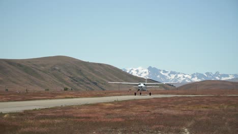 SLOWMO---Airplane-taking-off-with-snow-capped-rocky-mountains-in-background