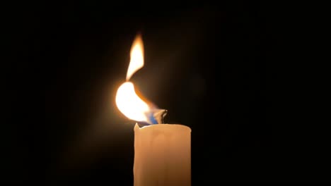 Close-up-of-single-candle-getting-blown-out