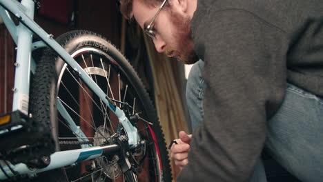 Man-Checking-Kickstand-and-Tightening-Bolts-on-Bike-SLIDE-RIGHT