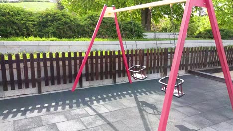 Two-Empty-Swings-are-Swinging-in-Playground