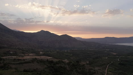 Luftsockel-Der-Landschaft-Und-Berge-Auf-Kreta,-Griechenland-Bei-Sonnenuntergang-Mit-Sonneneruptionen-Und-Warmen-Farben