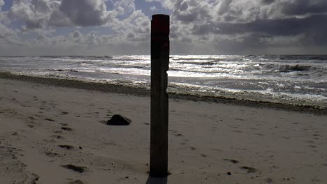 Beach-pole-on-the-North-Sea-coast,-filmed-with-backlight