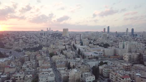 Peaceful-and-quiet-early-morning-aerial-clip-of-Amman-Jordan-taken-by-a-drone-which-slowly-pans-to-the-left-for-the-newly-risen-sun-and-a-flock-of-birds-passing-by