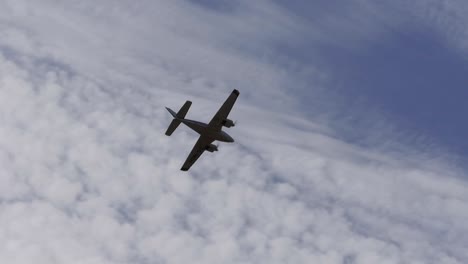 A-twin-prop-light-aircraft-flies-overhead-silhouetted-by-the-clouds