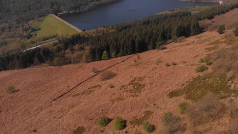 Drone-travelling-away-from-Lady-Bower-Reservoir-Whilst-panning-up-revealing-Lady-Bower-Reservoir-from-Bamford-Edge-in-the-Peak-District-shot-in-4K