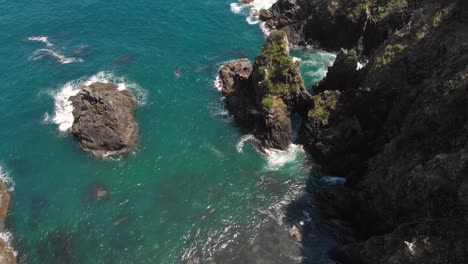 Aerial-drone-flying-over-big-sharp-rocks-near-a-paradise-coast