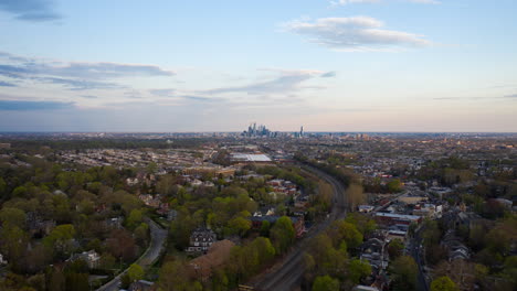 Luftaufnahme-Der-Skyline-Von-Philadelphia-Aus-Der-Ferne,-Die-Abends-Im-Sommer-Außerhalb-Von-Stadtvierteln-Und-Vororten-Zeigt
