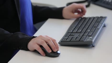 Tight-shot-of-woman-preparing-to-use-a-mouse-and-keyboard-at-a-computer