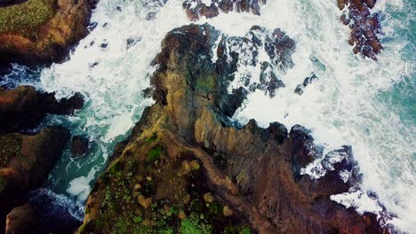 Waves-crash-into-a-rocky-cove-eroded-out-of-tall-cliffs-in-California