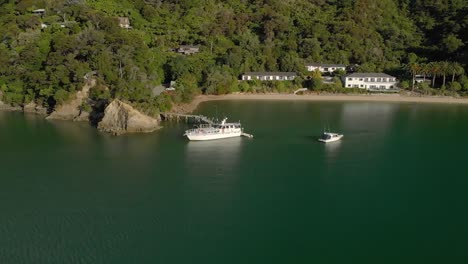 Boat-docked-in-bay-during-summer-in-Marlborough-Sounds,-New-Zealand