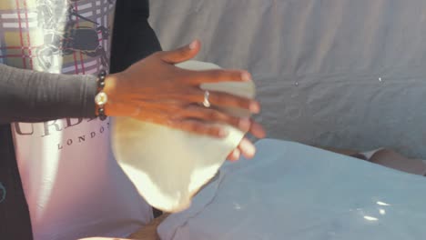 Woman-in-Moria-Refugee-Camp-stretches-dough-back-and-forth-between-hands-preparing-to-bake-bread-in-Tandoor-oven