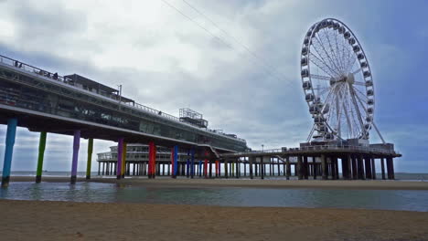 View-of-the-Ferris-wheel-and-the-pier-from-the-beach-in-Scheveningen,-Netherlands