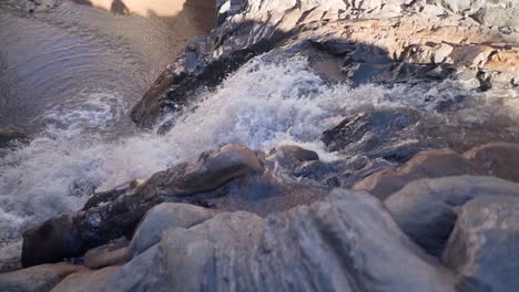 Slow-motion-water-fall-inside-a-canyon-near-San-Pedro-de-Atacama-desert,-northern-Chile,-South-America