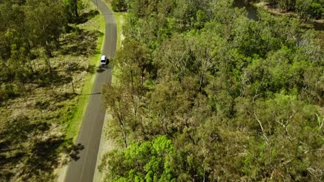 Aerial-view-of-a-campervan-on-the-road-through-green-bush-in-Australia