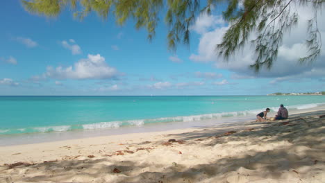 Grand-Cayman,-7-Meilen-Strand,-Schwenk-Auf-Zwei-Strandbesucher
