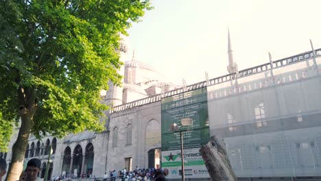 Unidentfied-people-exit-gate-of-Blue-Mosque-or-Sultan-Ahmet-Mosque,-a-popular-landmark-in-Istanbul,-Turkey