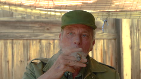 Slow-motion-clip-of-an-old-handsome-guy-in-army-clothes,-smoking-a-cigar